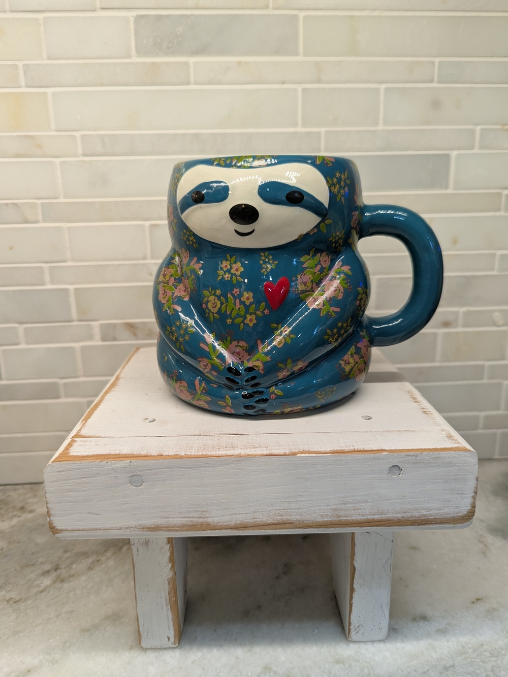 the Natural Life Sylvia Sloth Folk Mug, featuring a charming blue floral pattern